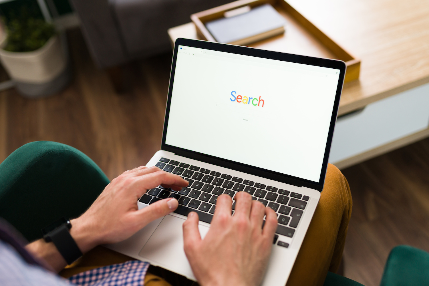 Adult person typing a word search on a website bar on his laptop. Man going online with a search engine